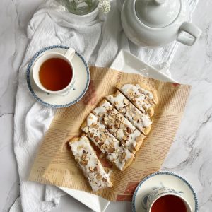 almond puff pastry swedish Kringle with 2 cups of coffee and a pot of tea.