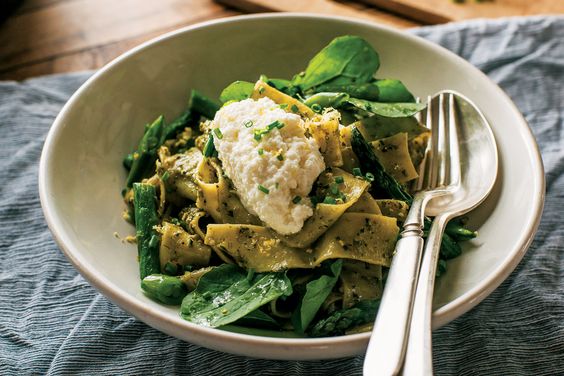 Pappardelle with Arugula Walnut Pesto in bowl with cutlery. 