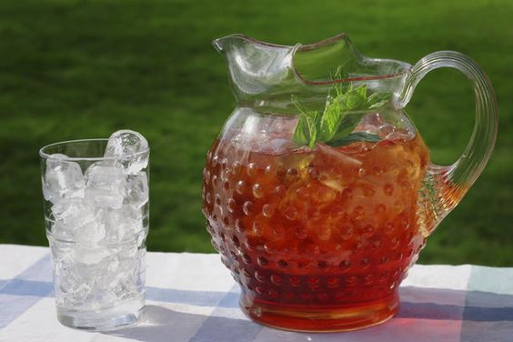 Sweet tea in a pitcher with a glass alongside. 
