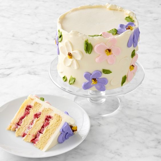 A white cake with colorful pastel flower decorations. 