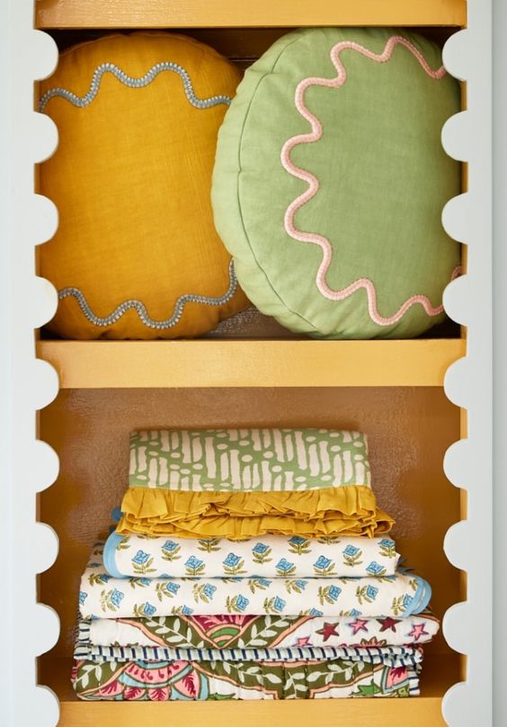 colorful pillows and bedding on scalloped shelves. 