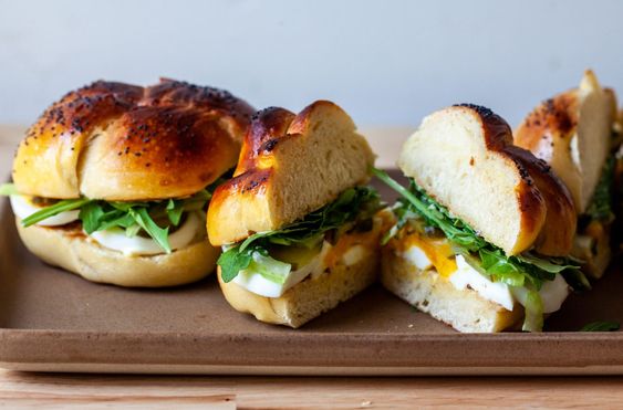 Sliced egg sandwiches cut in half on a board. 