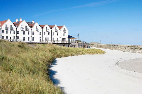 a row of white houses on a beach. 
