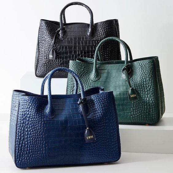 Black, green, and blue leather tote bags. 