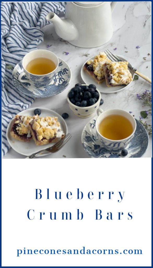 Blueberry crumb bars and 2 cups of tea in blue and white transfer ware cups and saucers.
