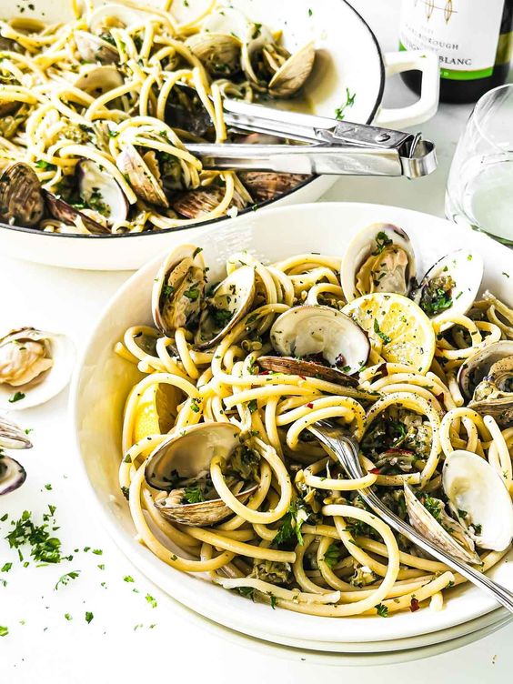 Two bowls of clams and pasta in broth 