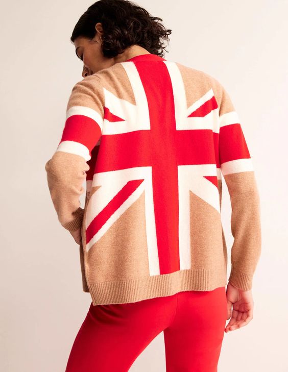 Woman with her back to you wearing a Union Jack flag sweater in the colors red, white and tan. 