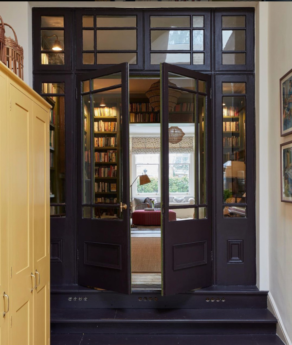 Sarah Brown Interiors-Aubergine library door in a yellow hallway. 