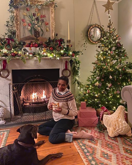 Paula Sutton Hill house vintage sitting in front of a fireplace in an English country house with her Labrador. 