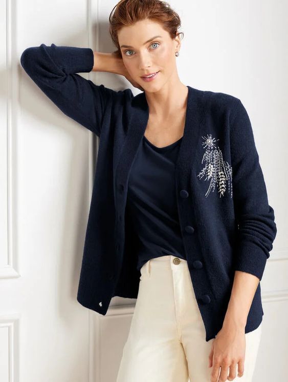 woman wearing a blue sweater with a rhinestone starburst on the right side. 