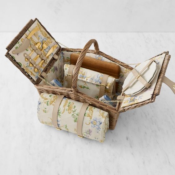 Williams Sonoma x Bridgerton, A picnic basket filled with plates, cups, and linens. 