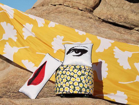 Diane von Furstenberg for Target, yellow and white beach towel and two white pillows, one with lips and one with an eye. 