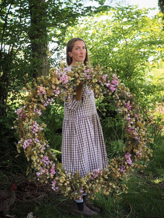 Bex Partridge Botanical Tales, woman holding a large dried flower wreath. 