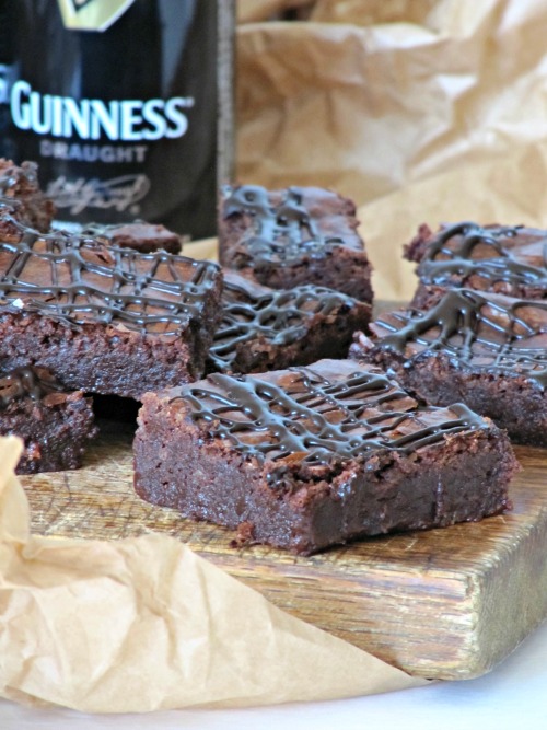 Guinness Stout Brownies with a drizzle of chocolate and a bottle of Guinness. 