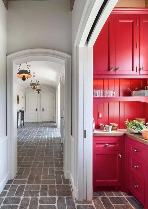 A long white hall with a red mud room. 