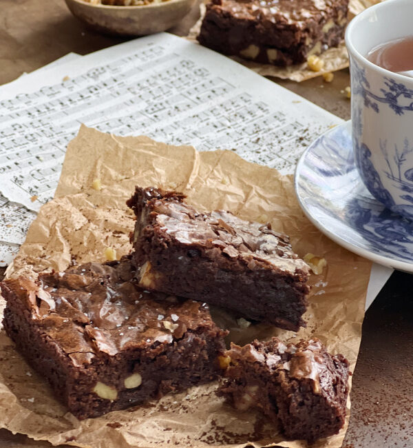 Ina Outrageous Brownies with walnuts and a blue and white toile cup and saucer of tea.