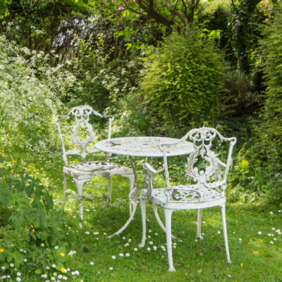White iron furniture in a spring garden