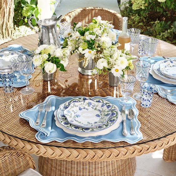 AERIN Garden Bouquet Dinnerware Collection on a wicker table. 