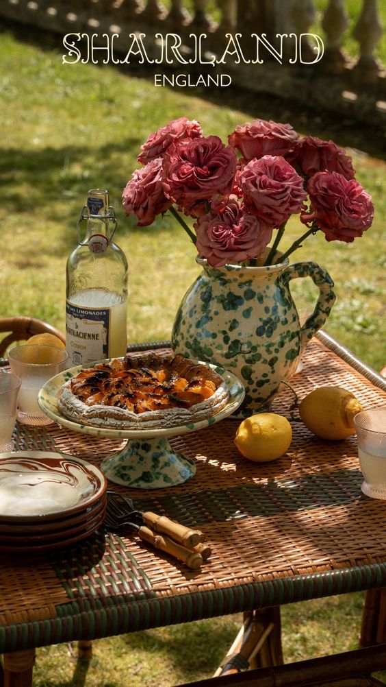 Romantic tablescape with flowers in a pitcher, fruit and a pie. 