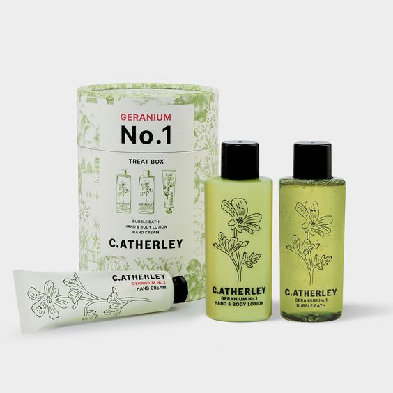 C.Atherley bath products with botanical illustrations on the clear glass bottles filled with green liquid. 