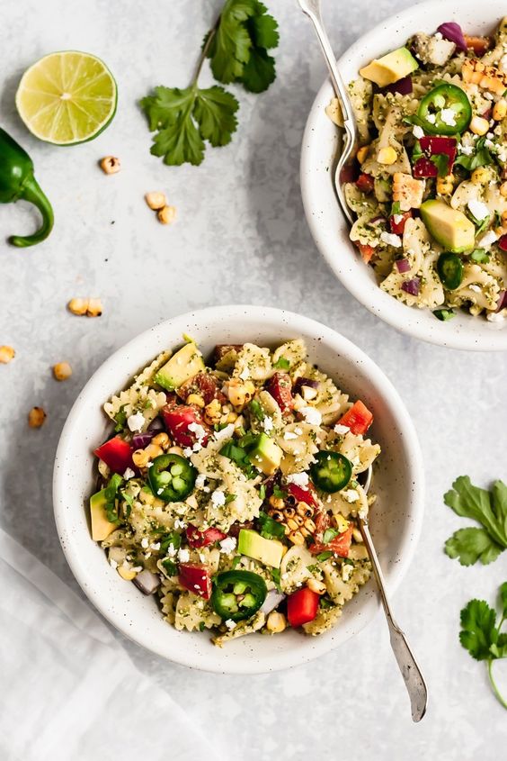 Street Corn Pasta Salad with sweet corn, red bell pepper, avocado, creamy goat cheese and a super addicting cilantro pesto.
