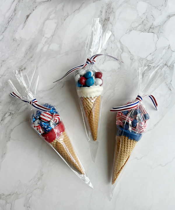 3 cones filled with red white and blue candy in cellophane with patriotic ribbon. 