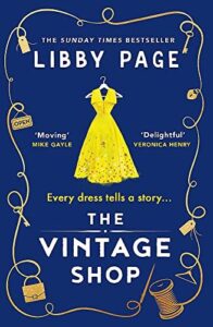 Book cover of The Vintage Shop, blue with a yellow dress on a hanger. 