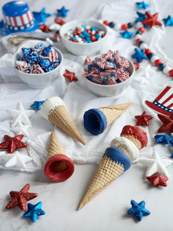 red, white and blue dipped sugar cones with 3 bowls of candy and patriotic stars 4th of July favors