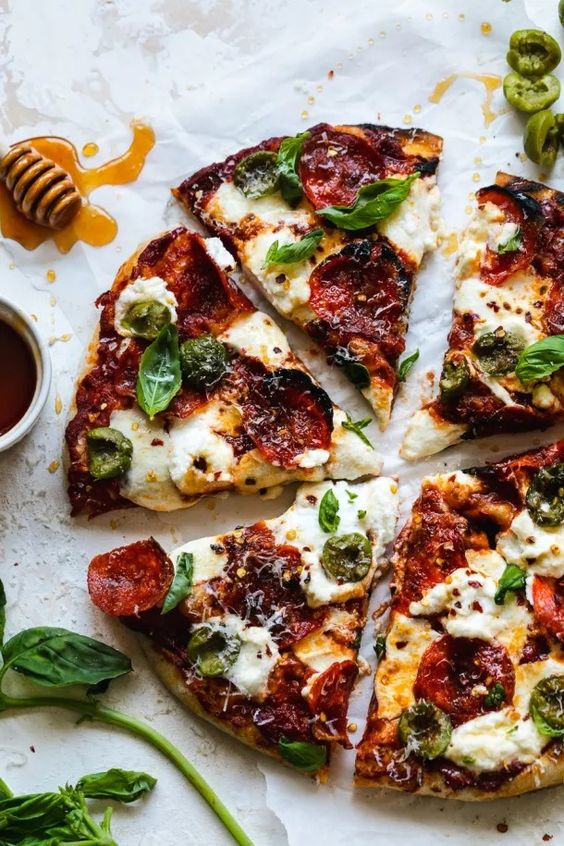 Pepperoni Pizza with Hot Honey, Ricotta, Olives, and Basil.