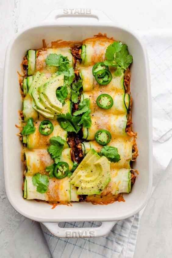 Zucchini Enchiladas in a white Staub pan. 