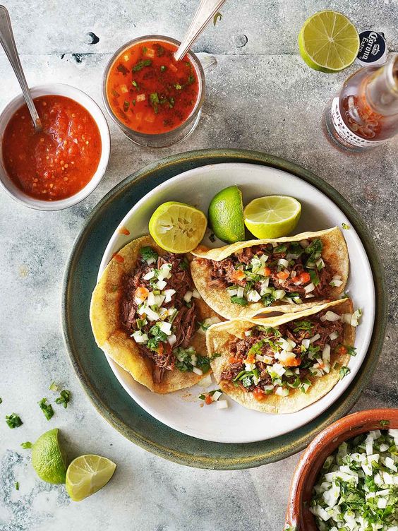 Beef Birria in tacos on a white plate. 