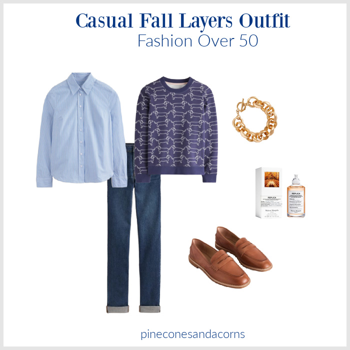 Fall Layers Outfit fashion over 50 with jeans, tan loafers, a blue and white stripe shirt, and a blue dachshund sweatshirt, perfume and a gold bracelet. 