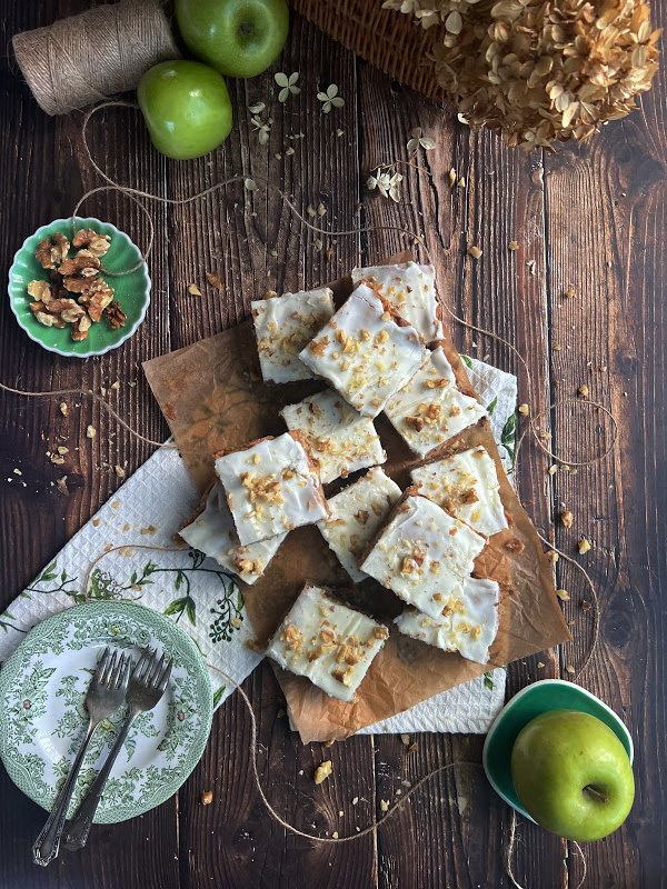 apple blondies with vanilla glaze and three green apples with a basket of dried hydrangeas.