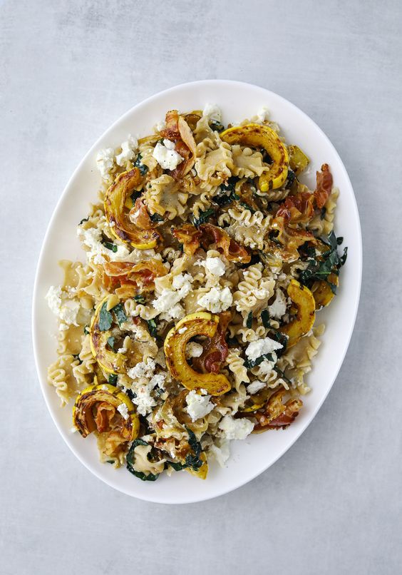 Fall pasta with delicata squash on a white oval plate. 