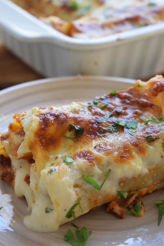 Beef & Cheese Cannelloni in a white pan and on a white plate. 