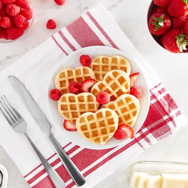 Valentines Day Gifts and Finds heart shaped waffles on a plate with berries. 