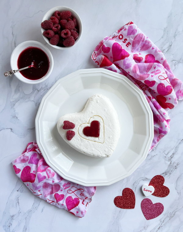 Coeur a La Creme With Raspberry Sauce on a white plate.