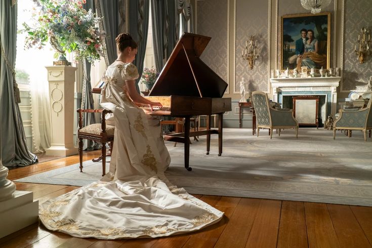 Woman in a white dress sitting at a piano.