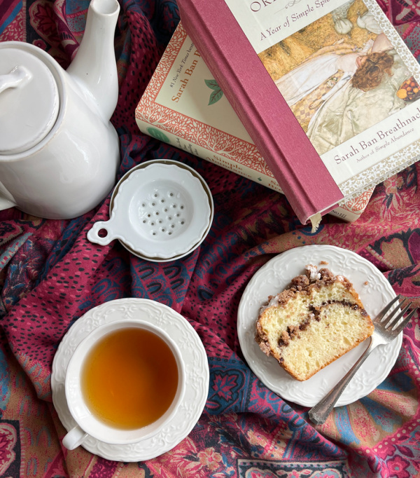Cup of tea 2 books and a slice of quick bread.