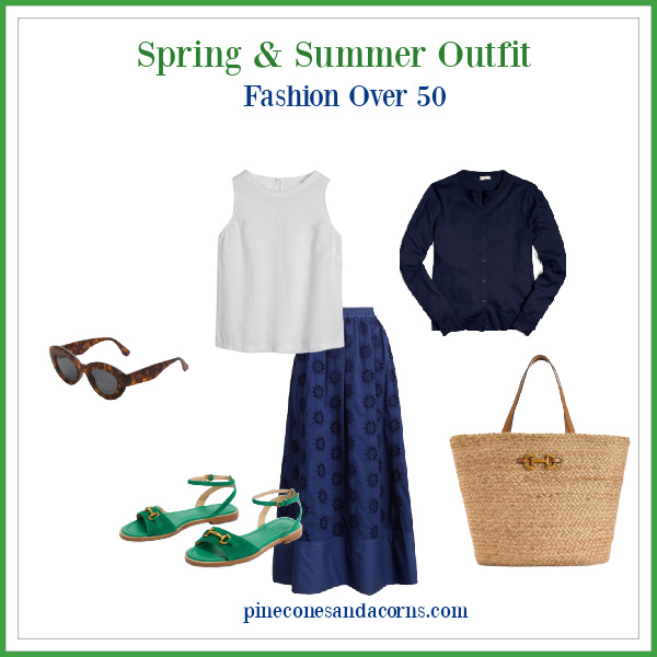 Spring and Summer skirt outfit Fashion Over 50 with blue eyelet skirt, white linen shell, blue sweater, green sandals with gold snaffle, brown sunglasses and a wicker bag with leather accents and a snaffle on the front.