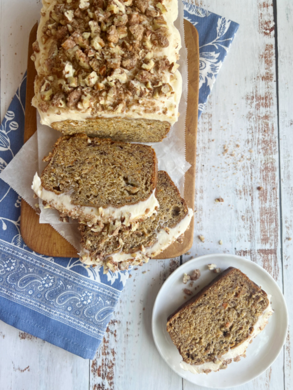 sliced carrot banana bread with cream cheese frosting.
