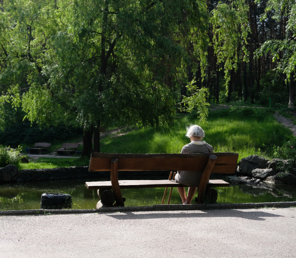 woman sitting alone reading on a bench. 