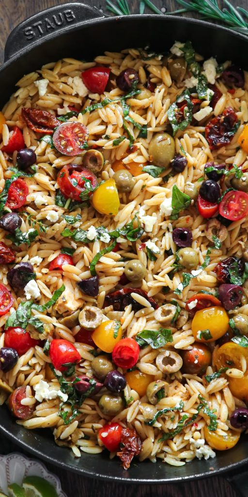 Greek Orzo with Tomatoes, Feta, Olives, and Fresh Basil in a black stub skilled.