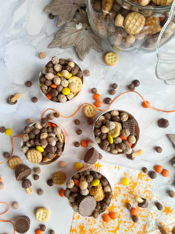 Peanut Butter Fall Snack mix in a pumpkin and scattered.