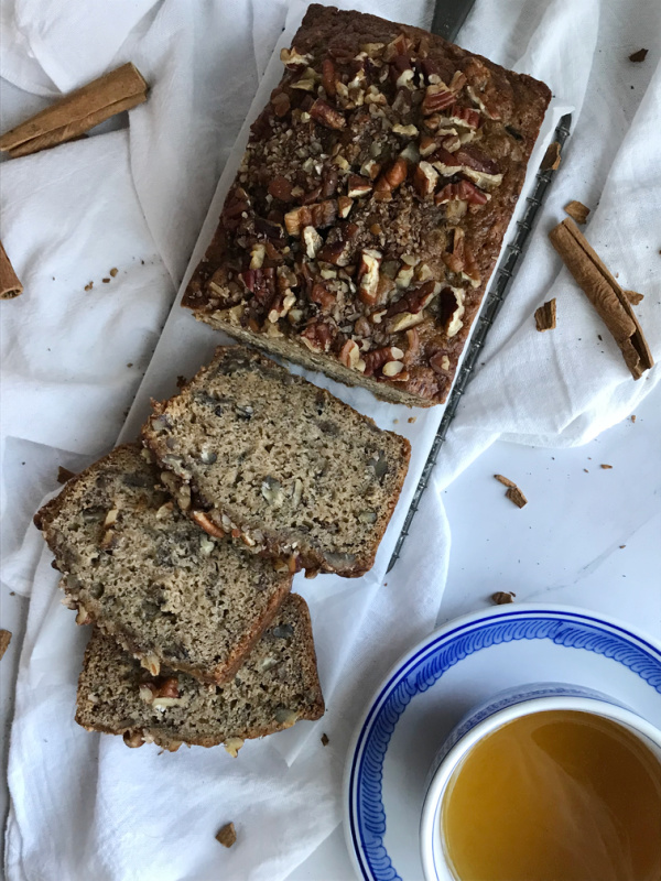 cinnamon spice banana bread with a cup of tea in a blue and white cup and saucer.