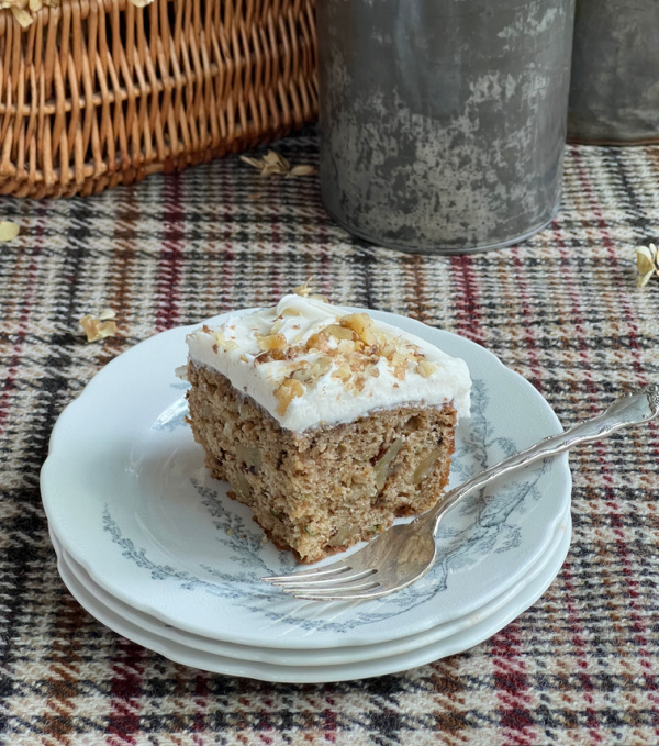slice of cake on a plate sitting on a plaid tablecloth.