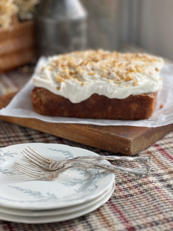 spiced zucchini cake with a stack of plates.