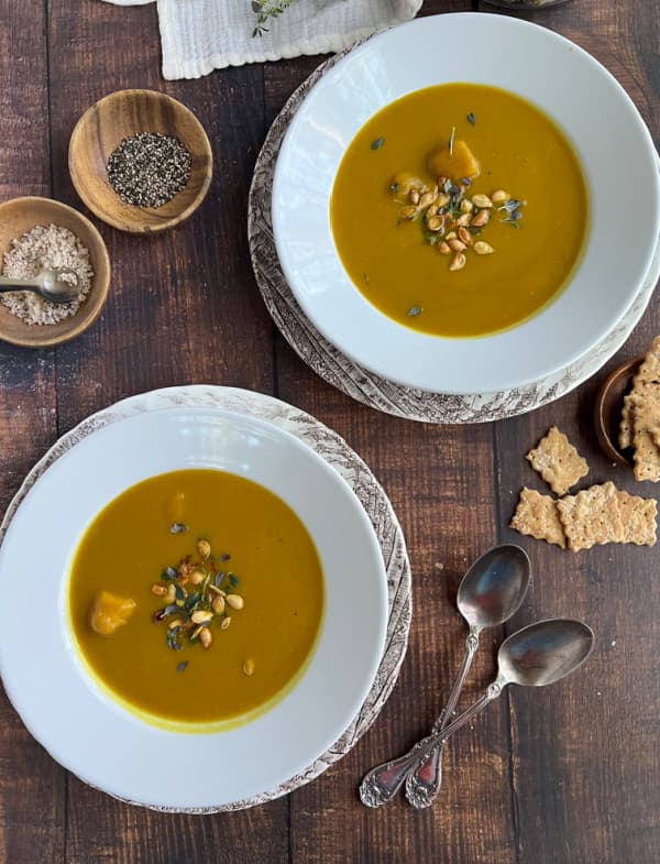 butternut-squash-soup-and-spoons-with-crackers-in-two-white-bowls.