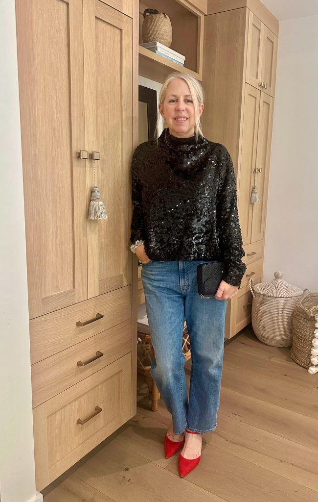 Woman wearing black sweater and jeans. 