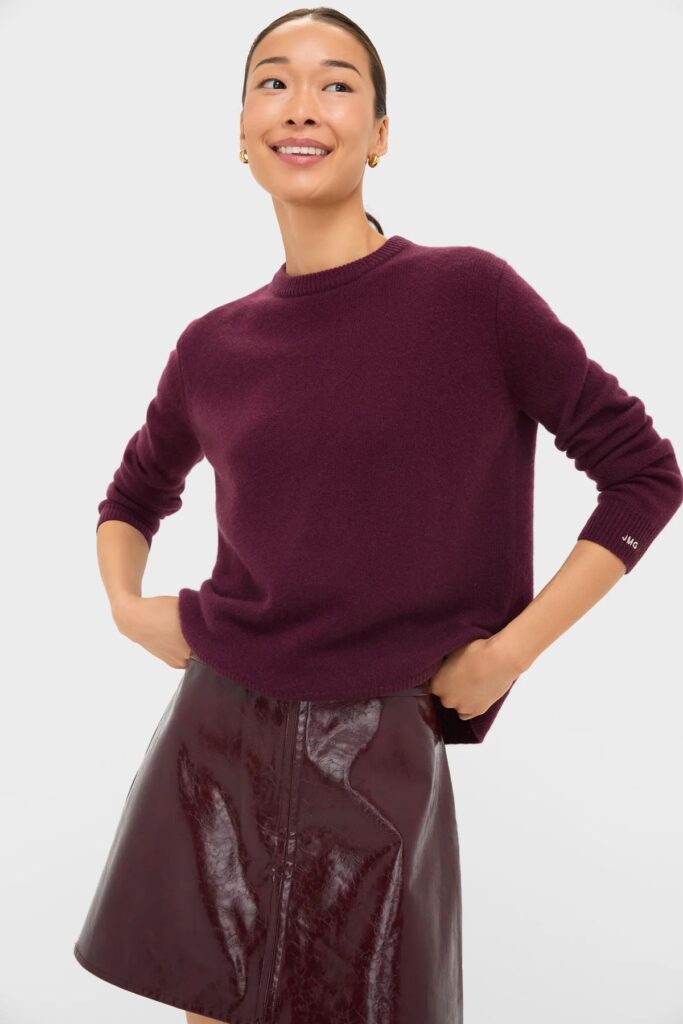 Woman wearing a Wine colored cashmere sweater and skirt.